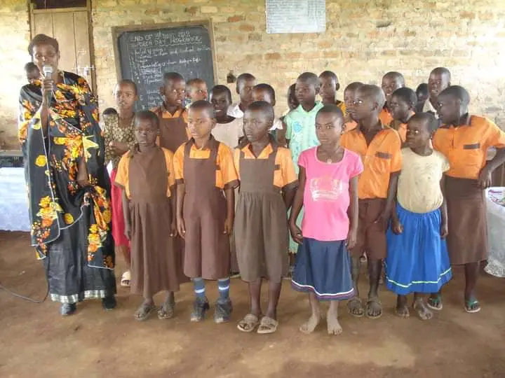 Primary-school children in uniform standing together in a classroom